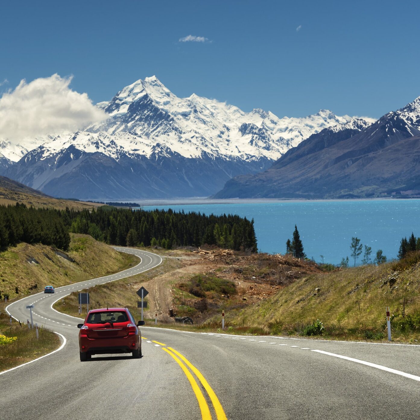 Red car on the road to Mt.Cook,New Zealand Red car going to the beautiful landscape lake tekapo, Mt.cook, Lupines fields, South island New Zealand